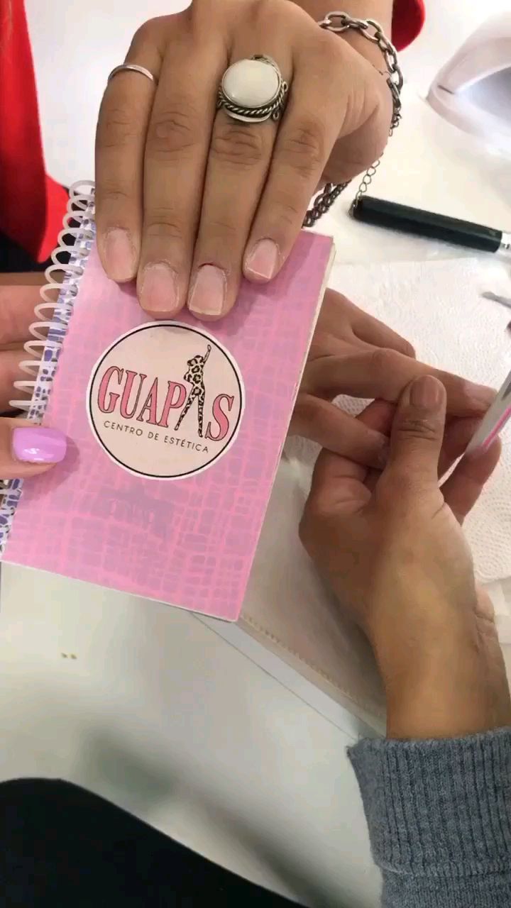 Manicuría en Guapas: manos sobre la mesa de trabajo junto a un cuaderno con el logo GUAPAS Centro de Estética